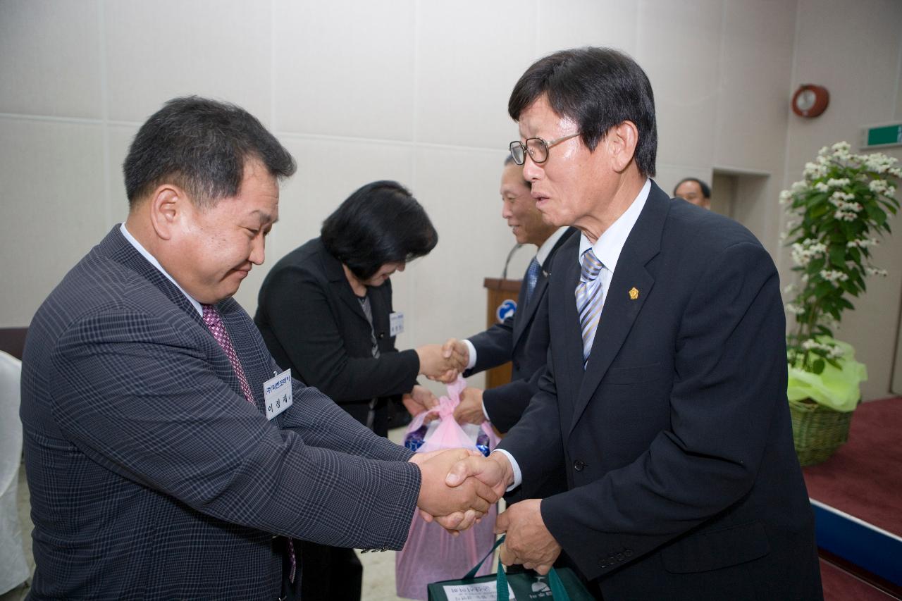 선물을 받으시는 문동신 시장님 옆에서 임원대표님과 악수하시는 의원님