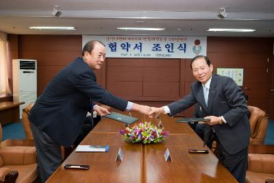 협약 체결서를 교환하고 악수하시는 회장님과 문동신 시장님