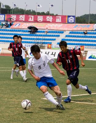 공을 몰고 가고 있는 선수와 뒤쫓아오는 선수