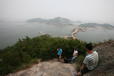 산을 올라온 사람들과 뒤로 보이는 선유도 전경