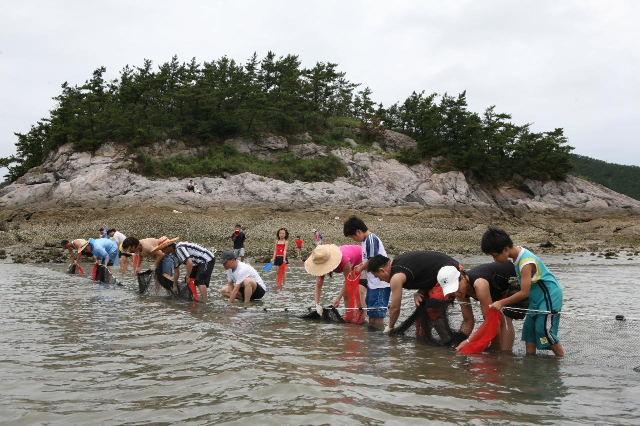 그물에서 물고기를 건지는 사람들 뒤에 보이는 바위산2