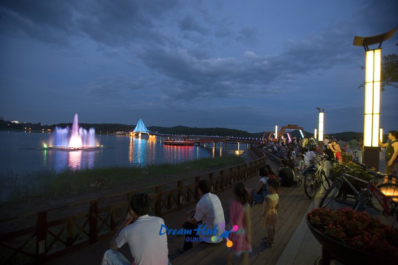 해질녘 불이 켜진 은파 물빛다리와 음악분수를 보고있는 시민들의 모습