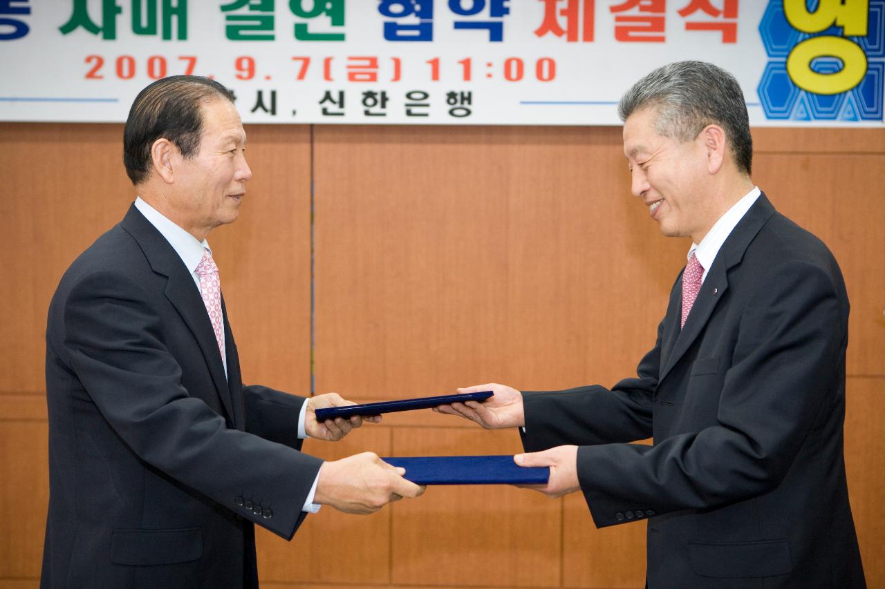 신한은행 도농 자매결연 협약서를 교환하시는 문동신 시장님과 관련인사