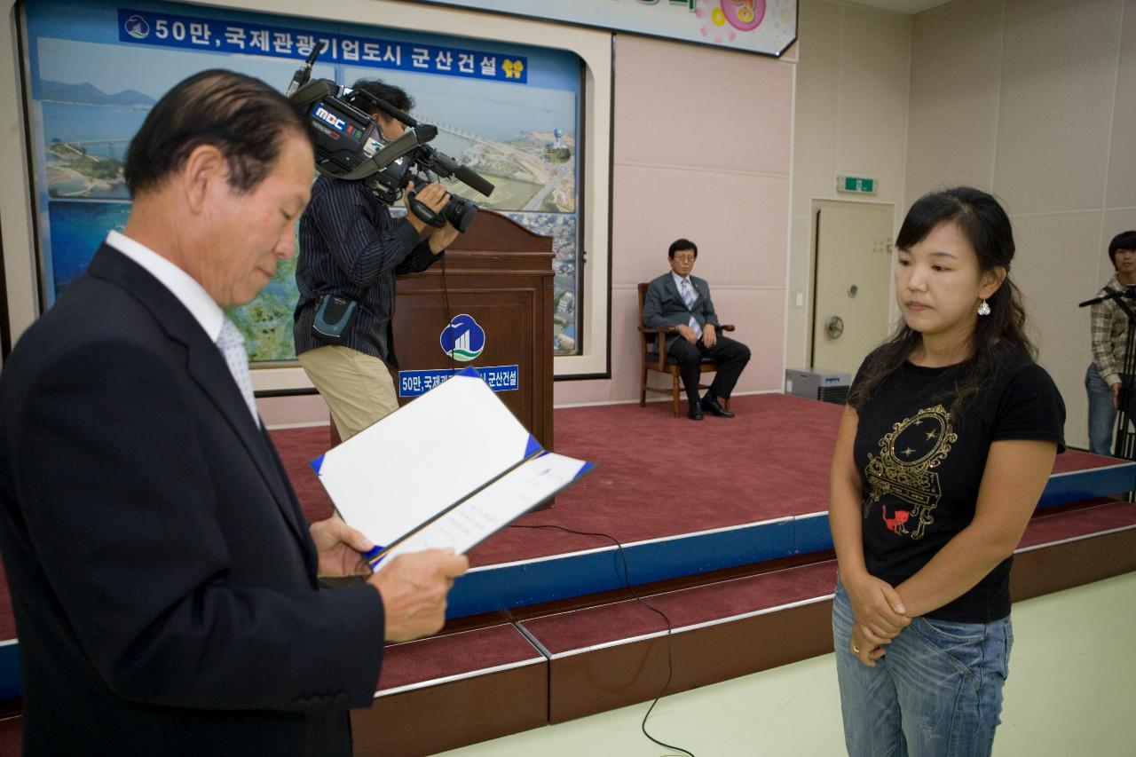 표창장을 보시는 문동신 시장님과 앞에 서계신 위원회 임원의 모습