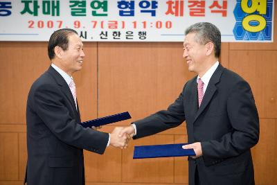 신한은행 도농 자매결연 협약서를 교환하시고 악수하시는 문동신 시장님과 관련인사1