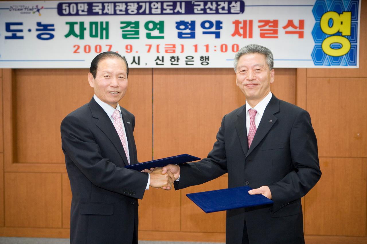 신한은행 도농 자매결연 협약서를 교환하시고 악수하시는 문동신 시장님과 관련인사2