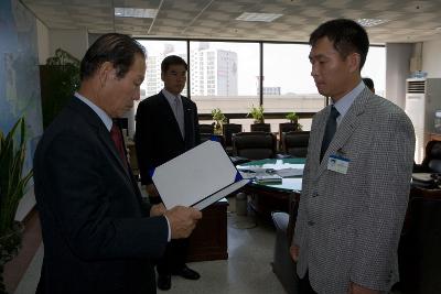 사령장을 보시는 문동신 시장님과 앞에 서있는 직원의 모습