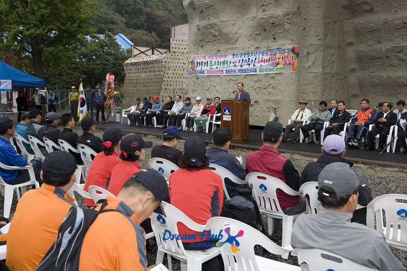 시장기쟁탈 산악대회 개회사를 하시는 문동신 시장님과 관련인사들과 관객석의 대회 참가자들의 모습1