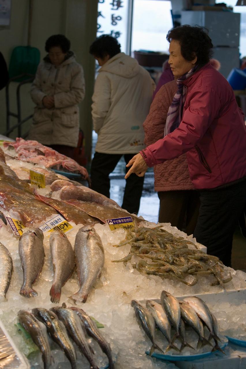 수산물을 가리키며 말하고 있는 사람