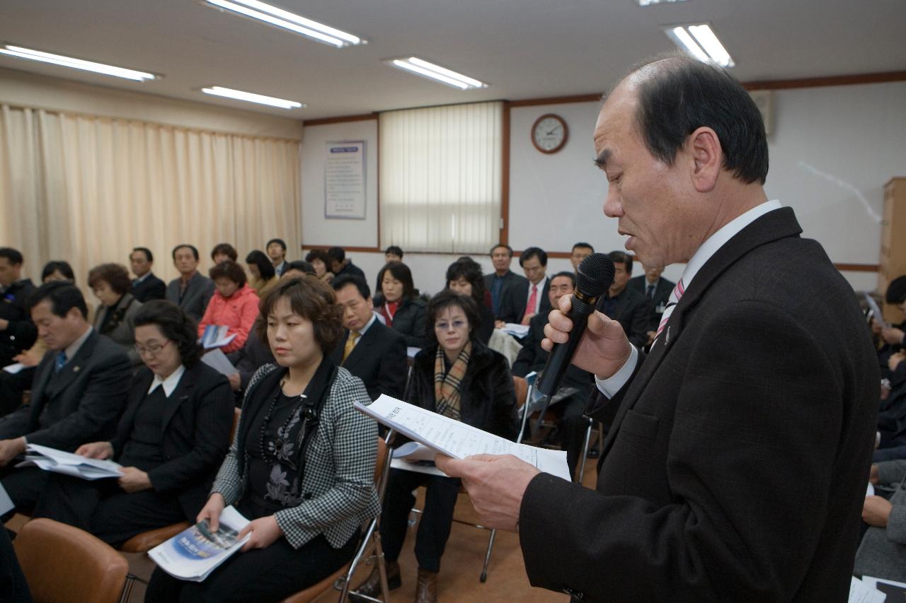 일어나 자료를 보며 말하고 계신 직원과 자리에 앉아 자료를 보며 듣고 계신 직원들