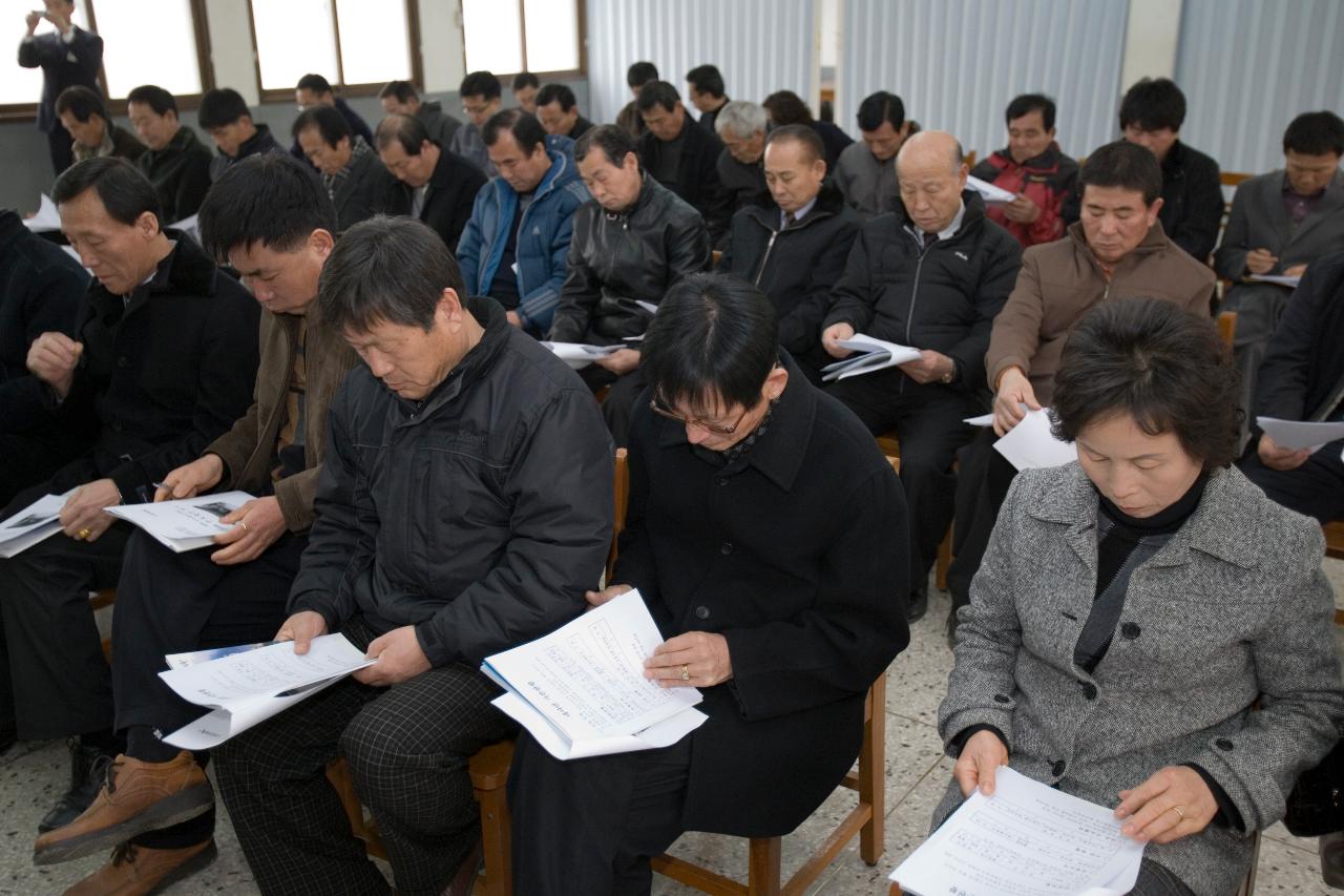 의자에 앉아서 연두순시자료를 보고 있는 사람들1