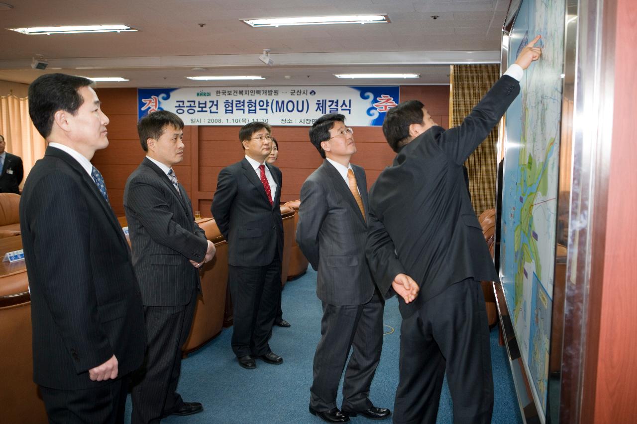 보건복지교육 MOU체결식이 있는 시장면담실에서 군산시개발계획도를 가리키며 말씀을 나누고 계시는 임원들1