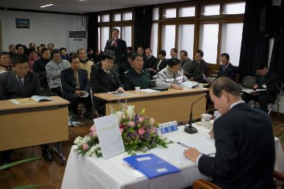 일어나 말하고 계신 직원과 자리에 앉아 자료를 보며 듣고 계시는 시장님과 직원들