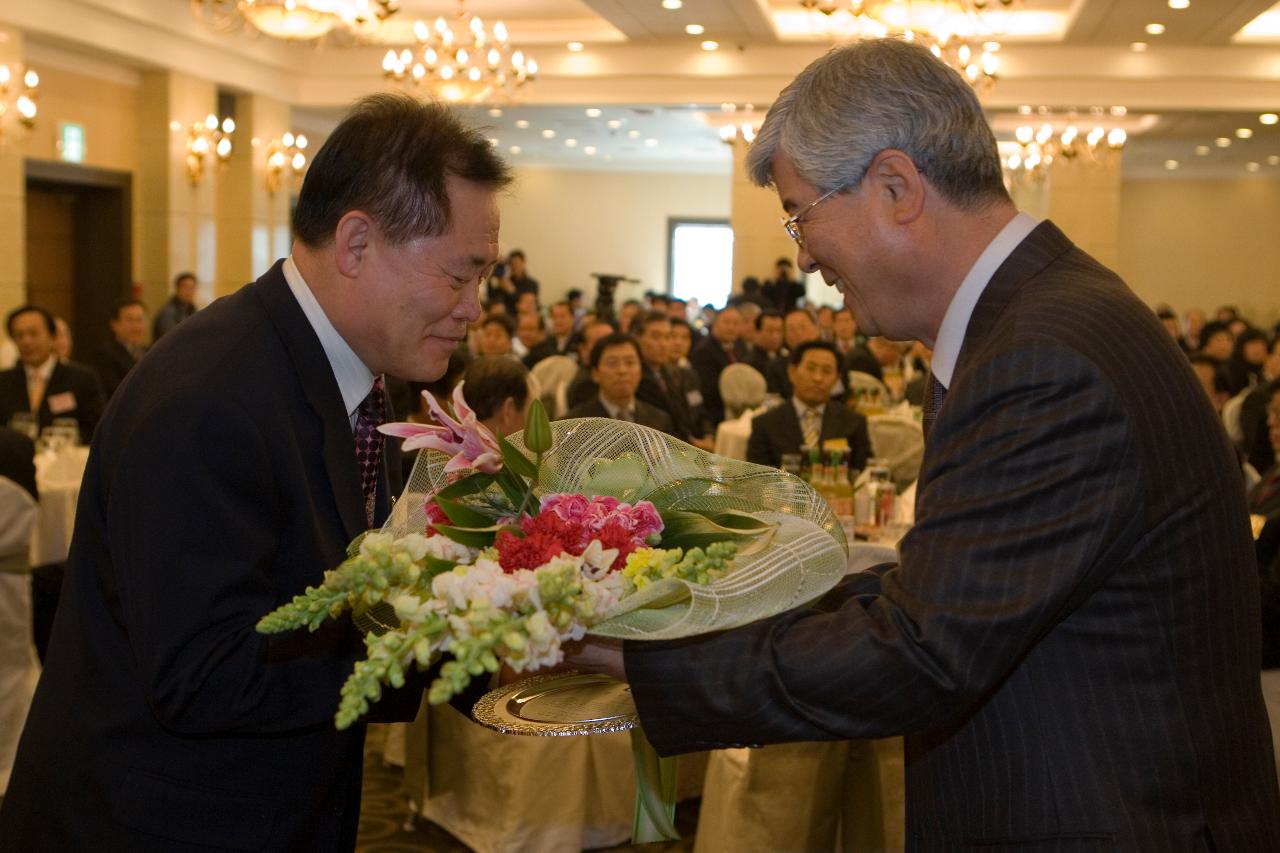 상패와 꽃다발을 수여하는 임원대표와 참석해 자리에 앉아 있는 임원들