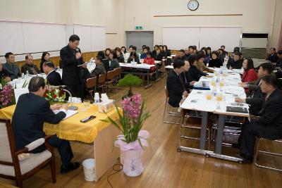 일어나 자료를 설명하는 직원과 앉아서 듣고 있는 시장님과 직원들1