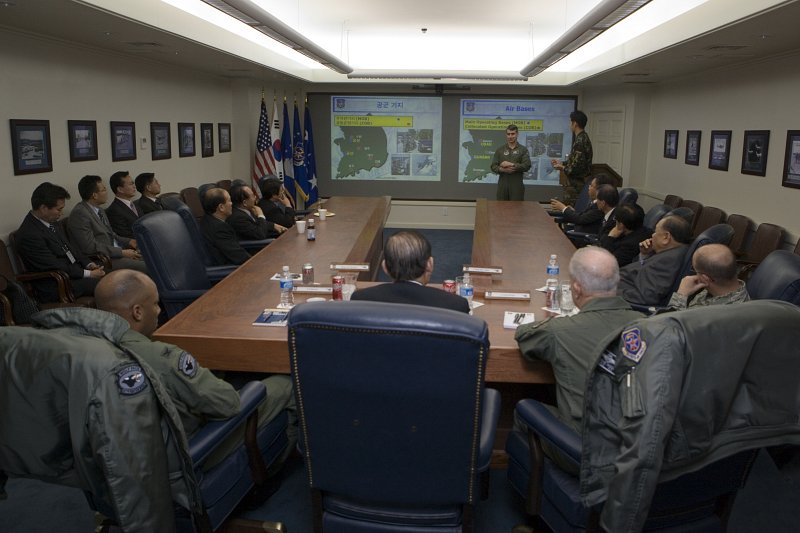 한국어와 영어로 나누어 자료를 준비해 발표하고 있는 미군과 듣고 있는 시장님과 임원들과 미군대표들2