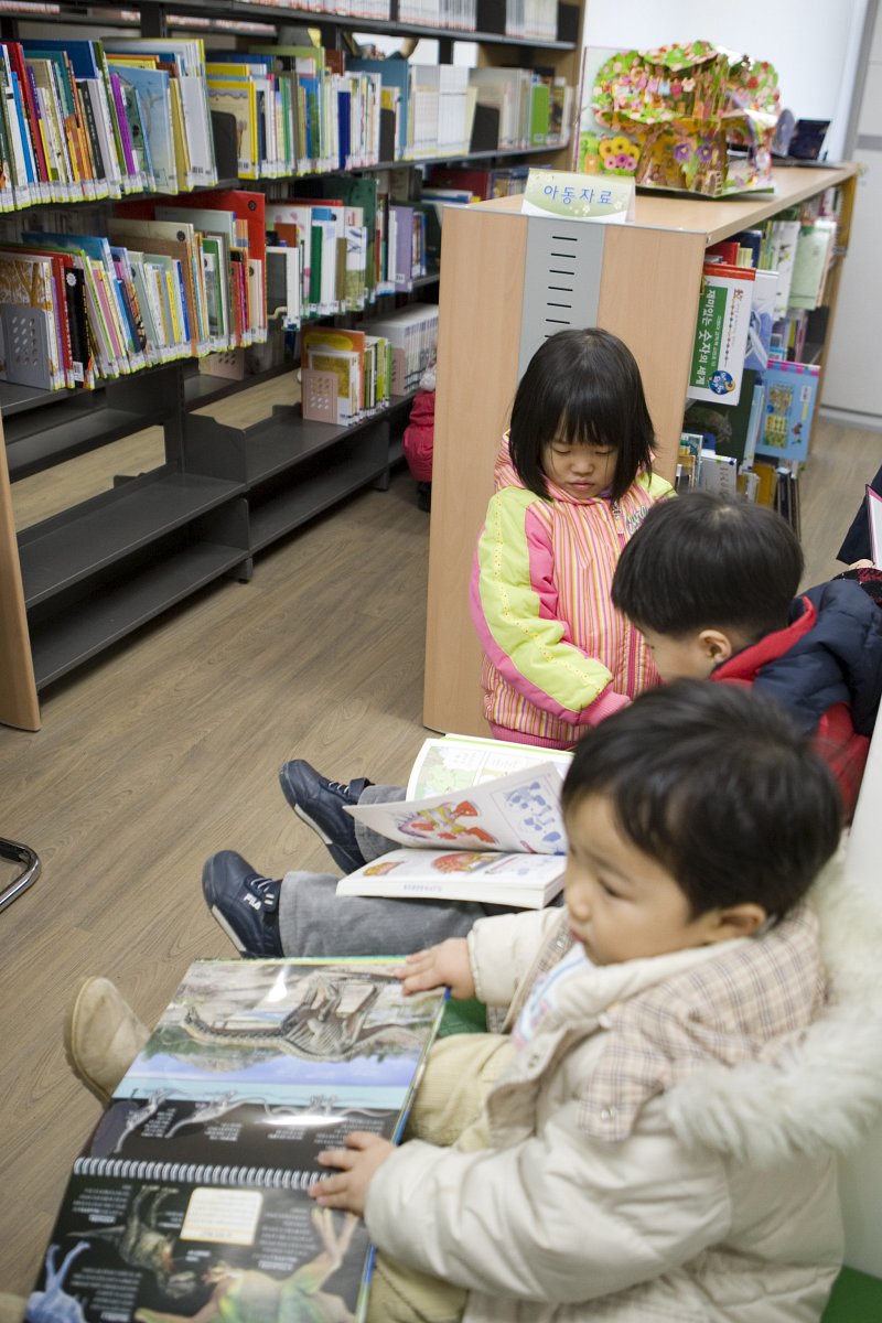 의자에 앉아 책을 보고 있는 아이들