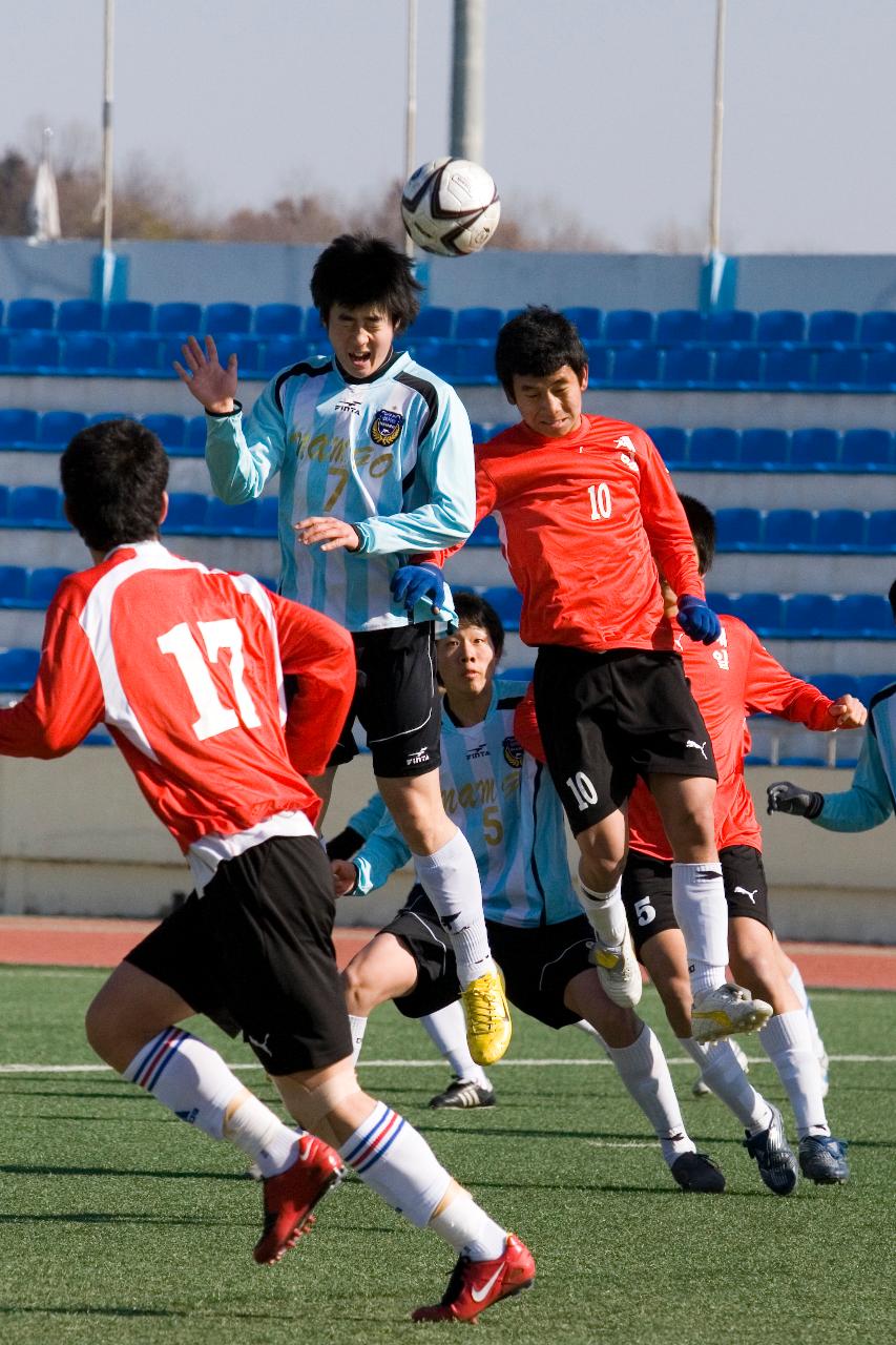 날아오는 축구공을 향해 점프하는 선수들