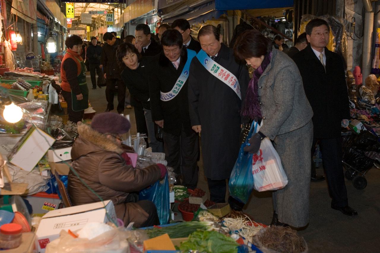 재래시장에서 장을 보는 주민들을 보고 있는 시장님과 임원들