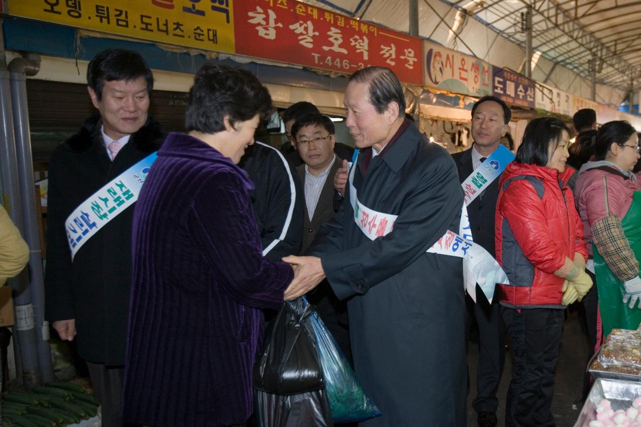 재래시장에서 장을 양손가득 본 시민을 만나 악수를 나누시는 시장님