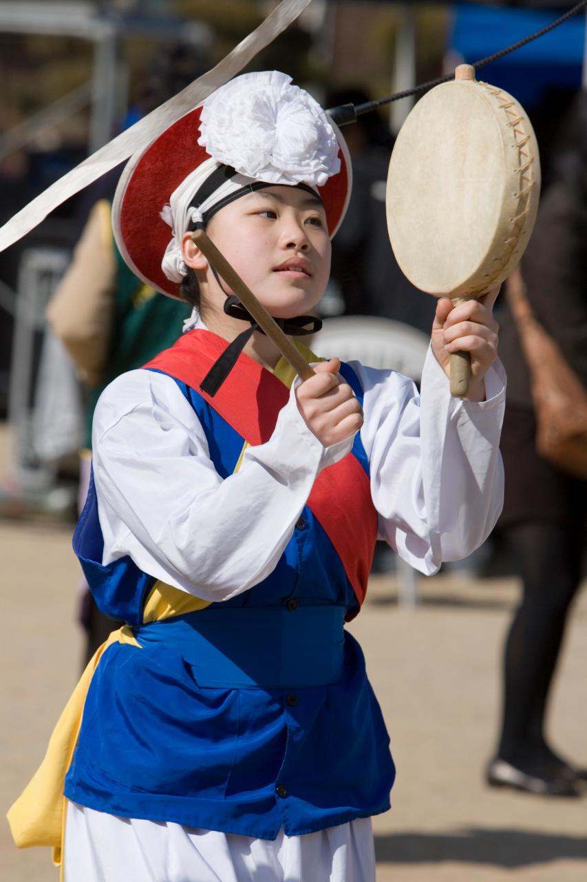 옷을 갖춰입고 사물놀이를 하고 있는 아이