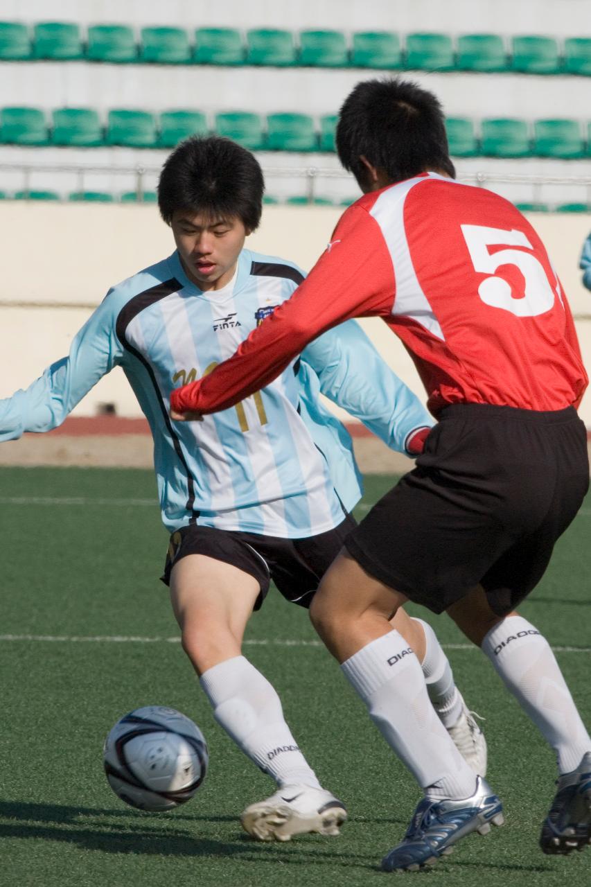 축구공을 향해 돌진하고 있는 두 선수