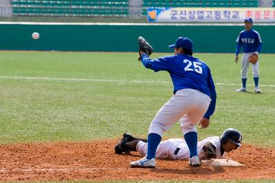 날아오는 공을 잡으려는 선수와 베이스에 도착한 선수