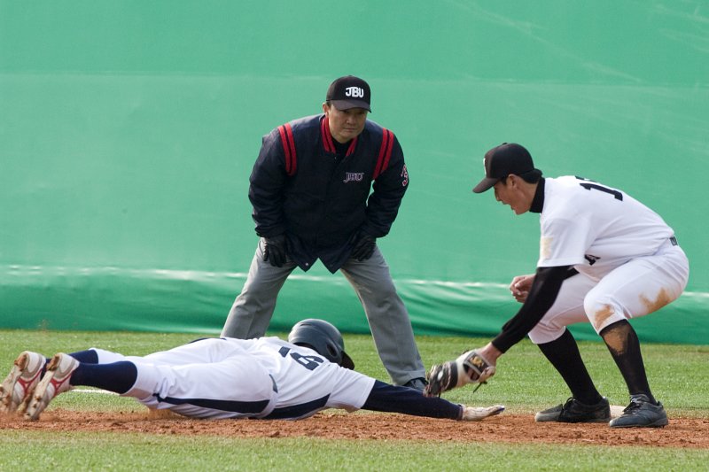 공을 받은 선수가 베이스로 몸을 던진 선수의 몸을 터치하고 있는 모습
