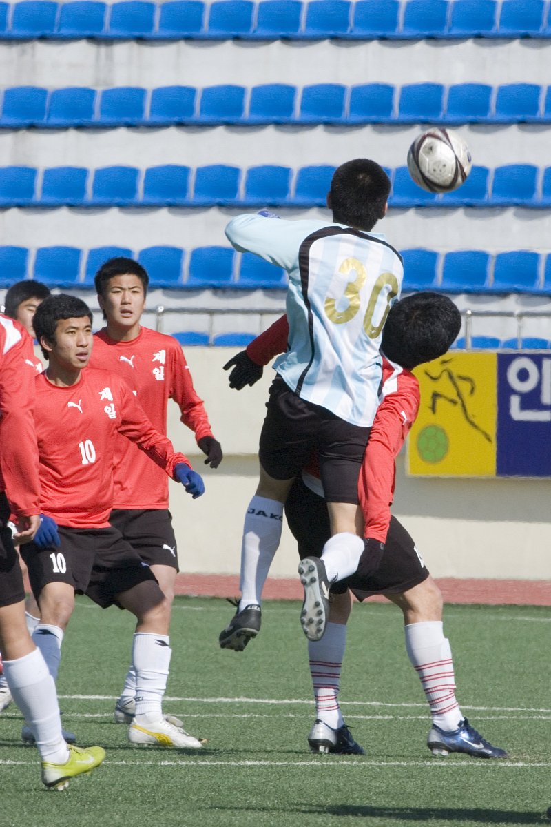 우수고교초청 축구대회에서 날아오는 축구공을 향해 헤딩을 하려고 점프하는 선수들