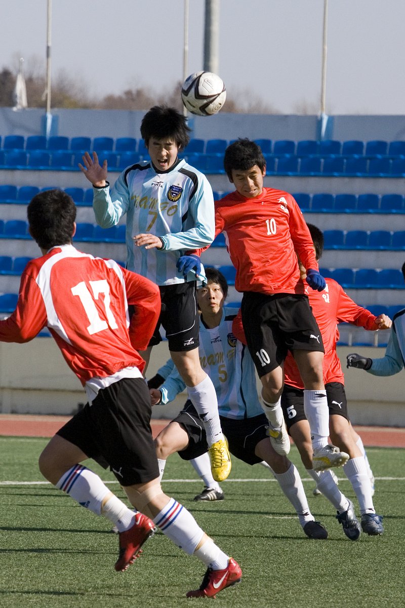 날아오는 축구공을 향해 점프하는 선수들