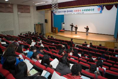 시장님의 사회봉사 오리엔테이션 전 수화공연을 하고 있는 학생들과 자리에 앉아 자료를 들고 보고 있는 학생들1