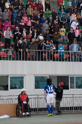 객석에서 축구공을 받고 있는 관객들과 아래 서 있는 축구선수