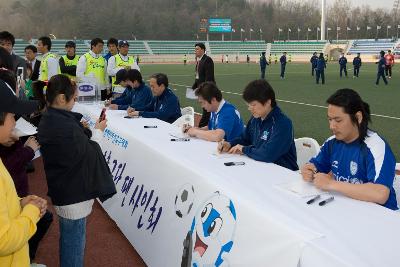 팬사인회를 준비하고 있는 연예인축구선수들과 앞에서 카메라로 사진을 찍고 있는 아이들