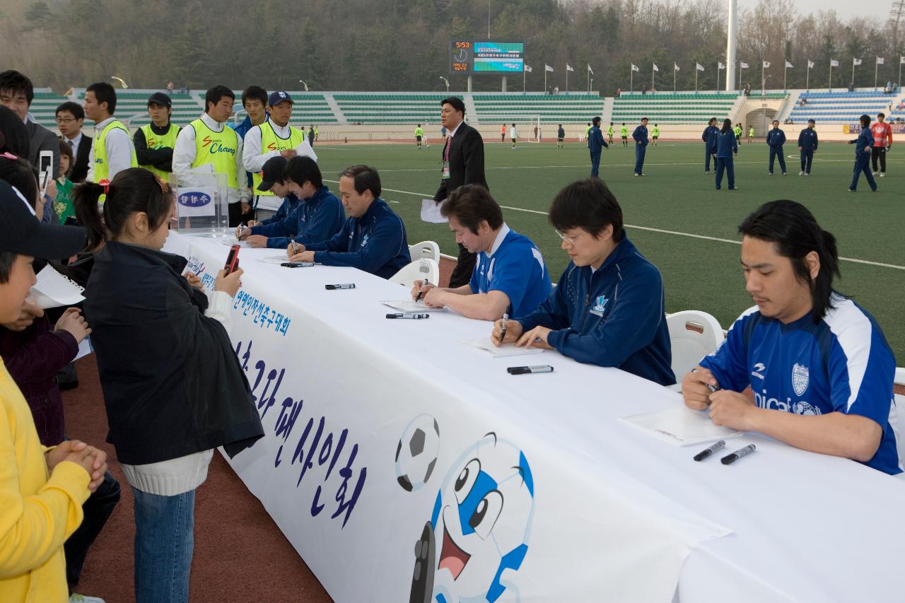 팬사인회를 준비하고 있는 연예인축구선수들과 앞에서 카메라로 사진을 찍고 있는 아이들