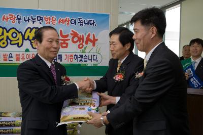 친환경쌀을 주고 받으며 악수를 나누고 있는 시장님과 관련인사들1