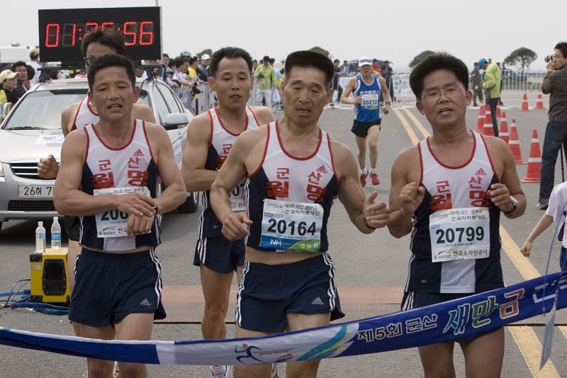 결승선을 함께 나란히 들어오고 있는 군산월명마라톤복을 입고 달리는 참가자들