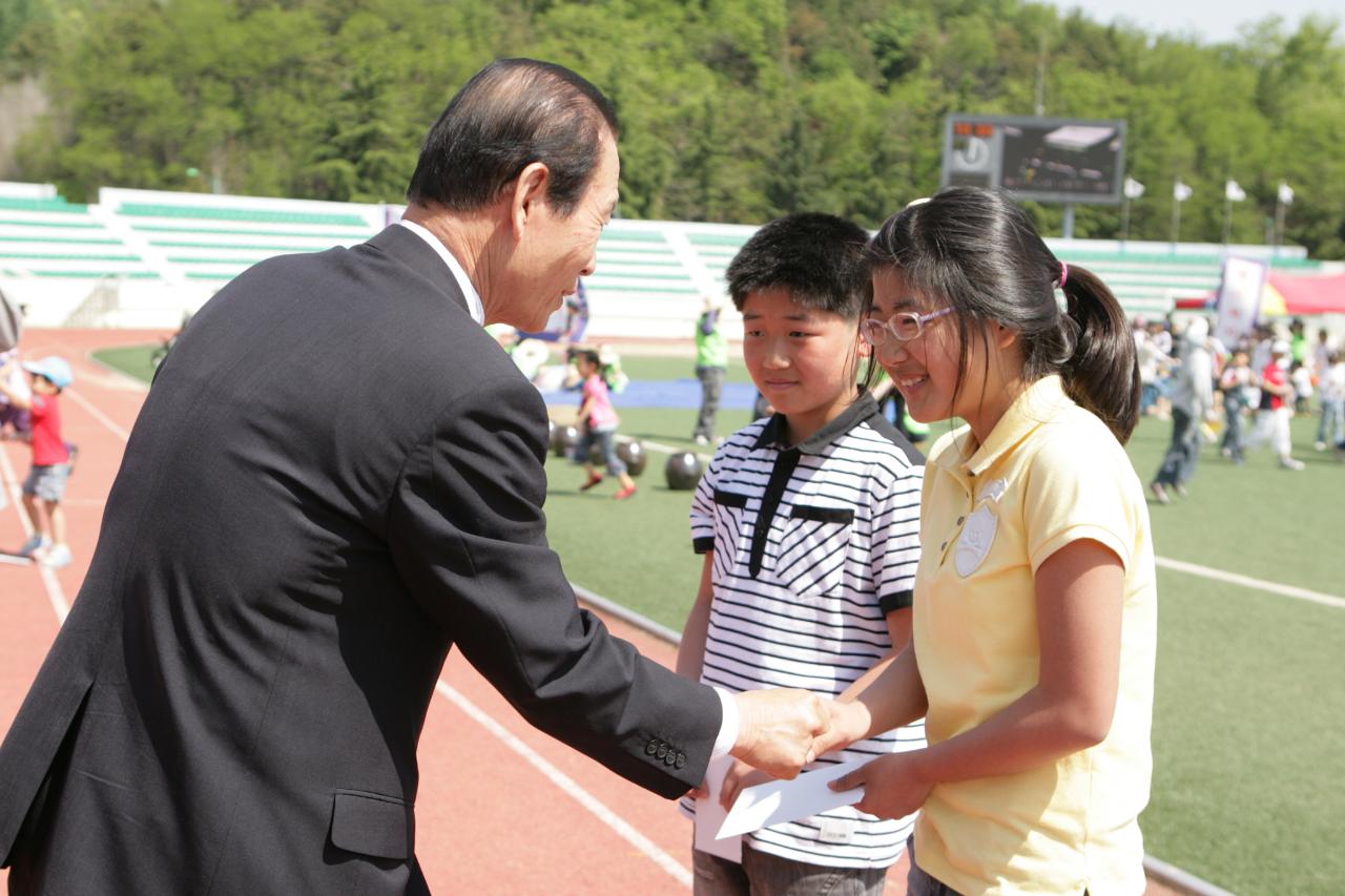 어린이대표들에게 봉투를 주며 악수하는 시장님2