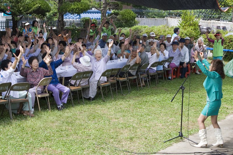 앞으로 나와 노래를 부르고 있는 가수와 즐거워하시는 어르신들1