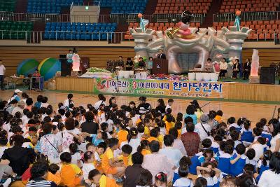 무대 위에서 말씀하고 계신 시장님과 바닥에 앉아 듣고 계신 어르신들과 어린이들2