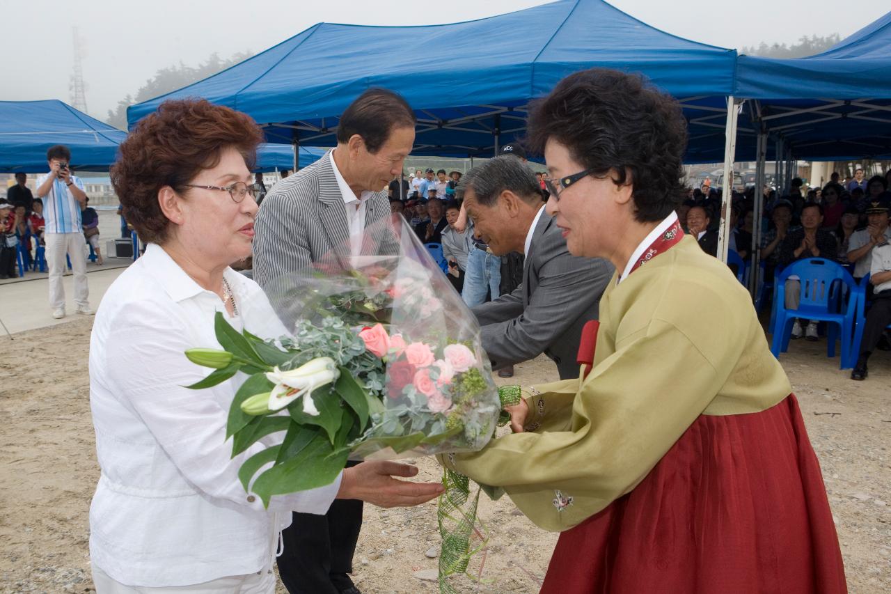 꽃다발을 전달해주고 있는 관련인사들