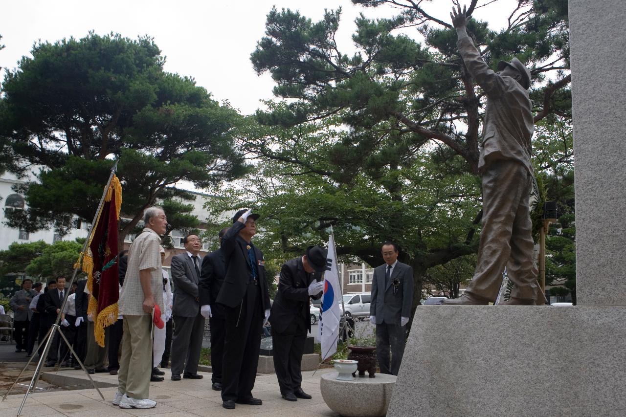 학도병의 동상앞에서 태극기를 꽂아놓고 향을 피우고 있는 관련인사들