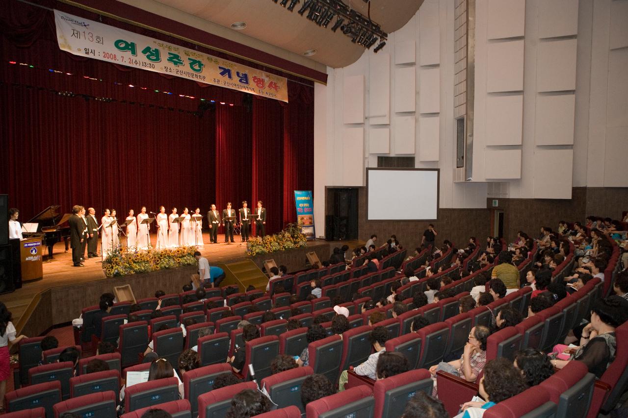 여성주간 기념행사로 무대 위에서 피아노 연주와 합창 공연을 하고 있는 공연단과 보고 있는 사람들