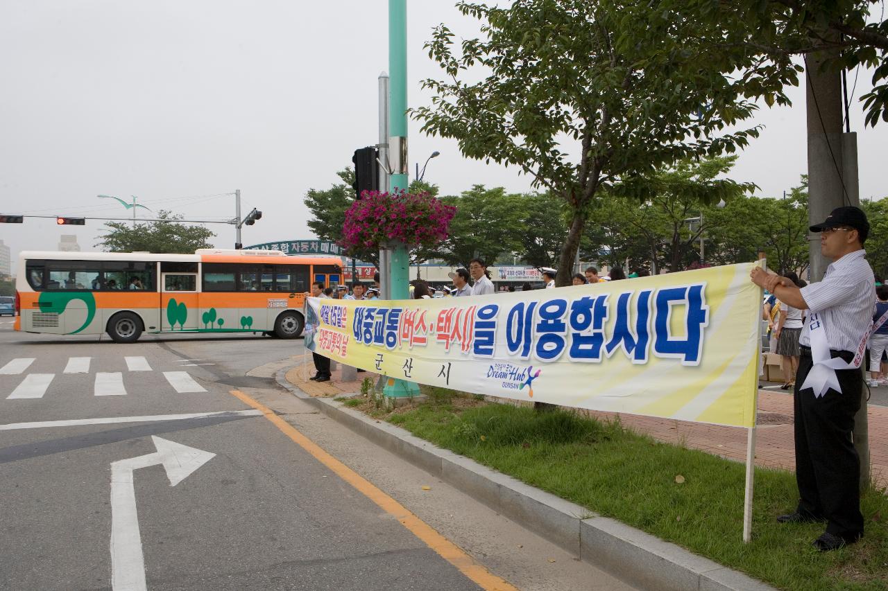 대중교통을 이용하자는 현수막을 들고 있는 사람들