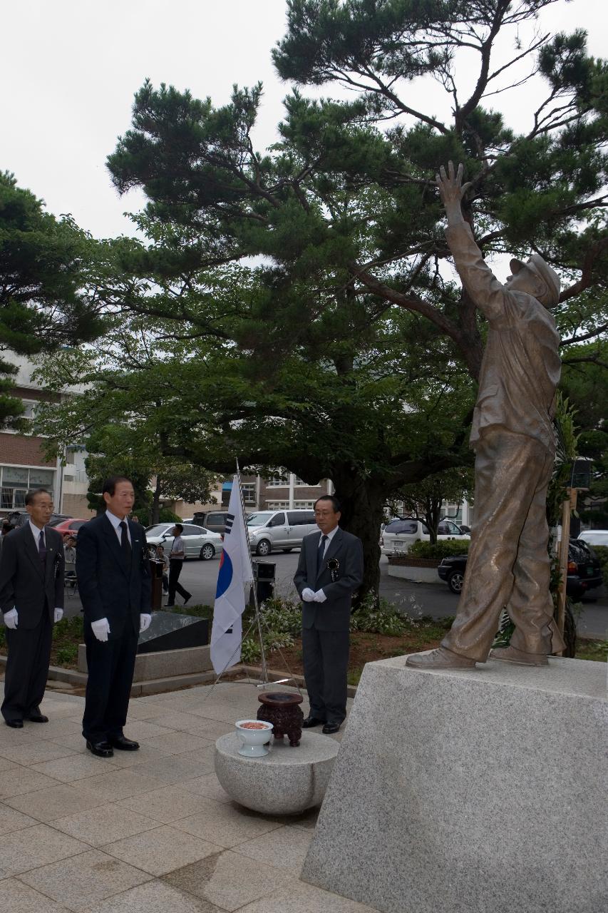 학도병의 동상앞에서 태극기를 꽂아놓고 향을 피우고 있는 시장님