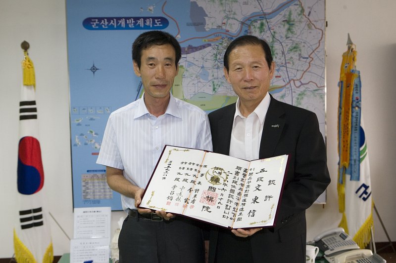 한국기원 단증을 펼쳐들고 기념사진을 찍고 있는 시장님과 대표님