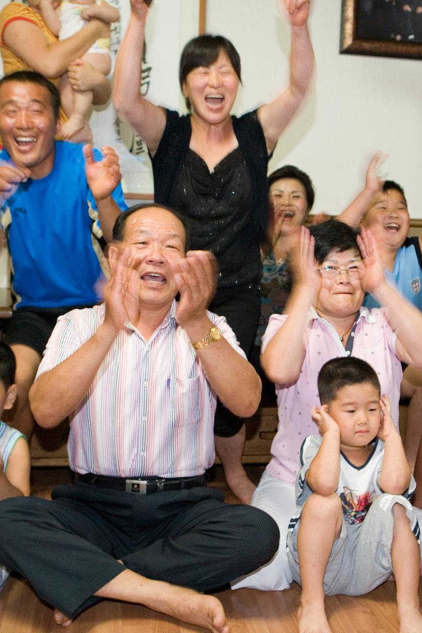 거실에 모여 앉아 박수를 치며 좋아하고 있는 박성현선수의 가족12