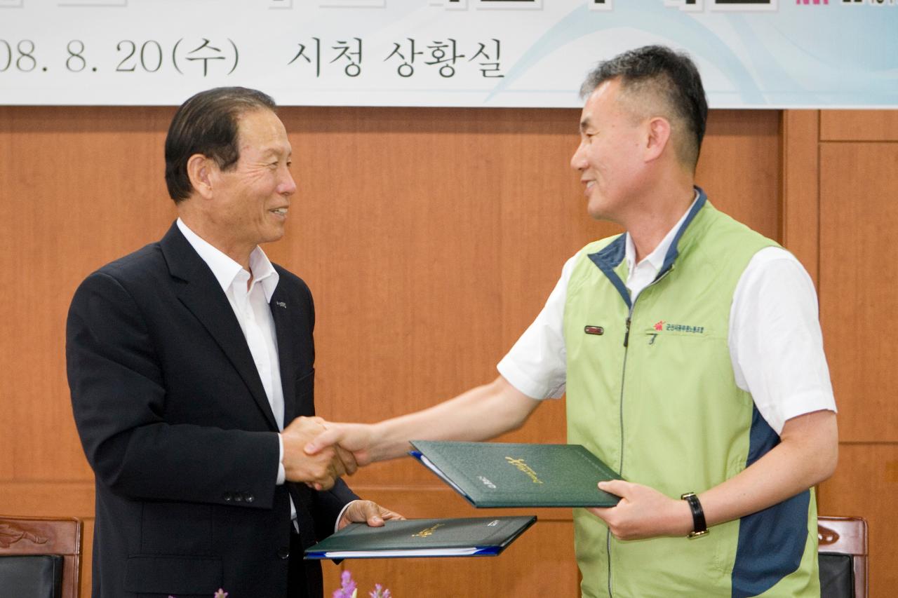 체결서를 주고 받으며 악수를 나누고 있는 시장님과 대표님