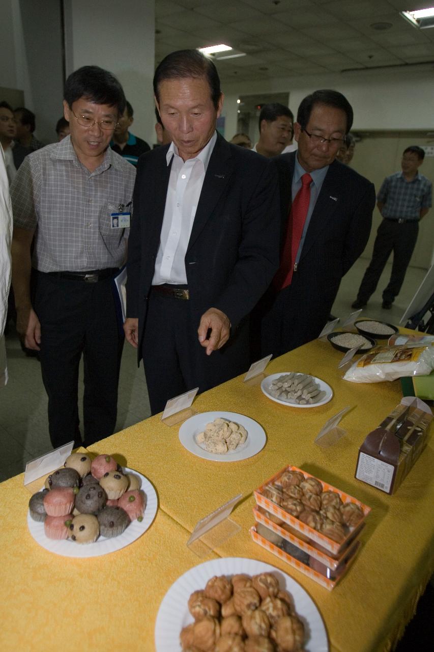 시식회에 전시된 음식들을 보고 있는 시장님과 관련인사들