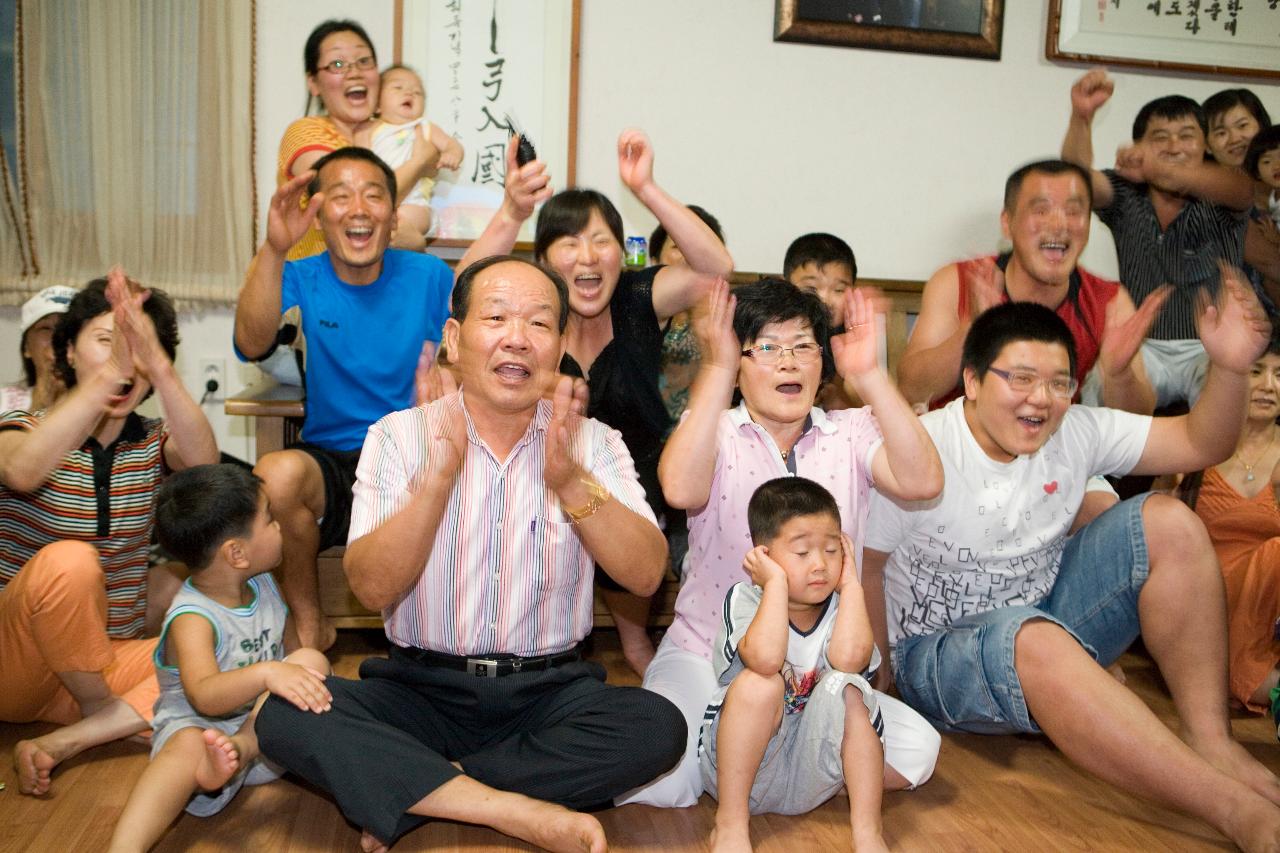 거실에 모여 앉아 박수를 치며 좋아하고 있는 박성현선수의 가족11