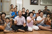 거실에 모여 앉아 박수를 치며 좋아하고 있는 박성현선수의 가족2사진(00002)